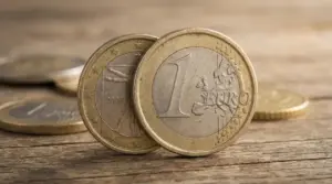 Monete da 1 euro su una superficie in legno, una coniata nel 2002 in primo piano